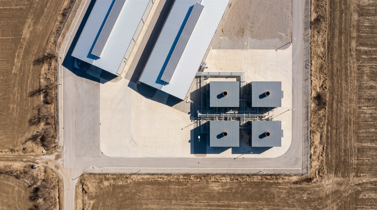 Conceptual illustration of a gas-fired generation plant beside data center halls, seen from above